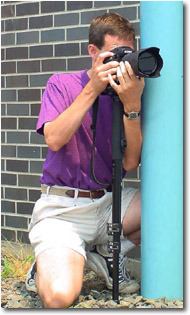 фотограф, использующий монопод и стену